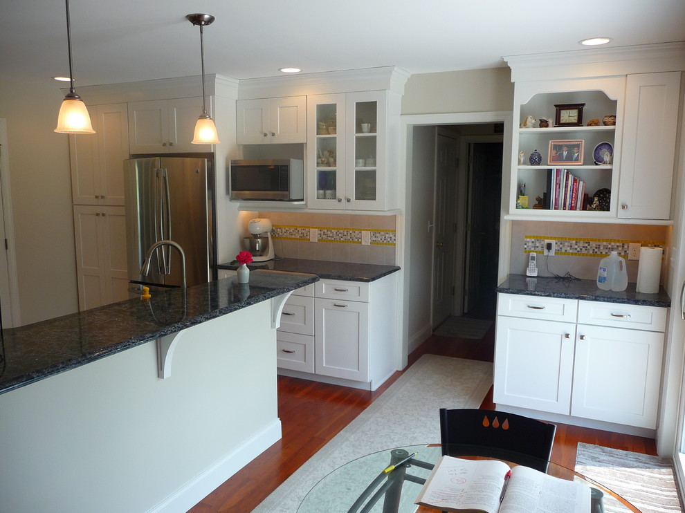 Inspiration for a mid-sized transitional l-shaped medium tone wood floor eat-in kitchen remodel with a double-bowl sink, recessed-panel cabinets, white cabinets, quartz countertops, multicolored backsplash, ceramic backsplash, stainless steel appliances and a peninsula