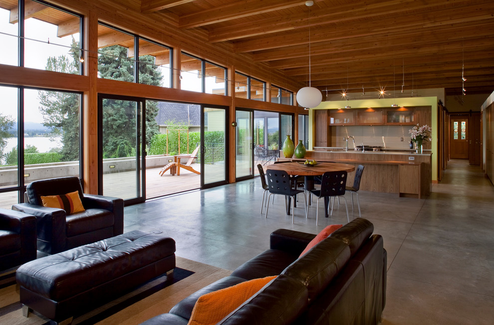 Contemporary open plan dining in Portland with concrete floors.