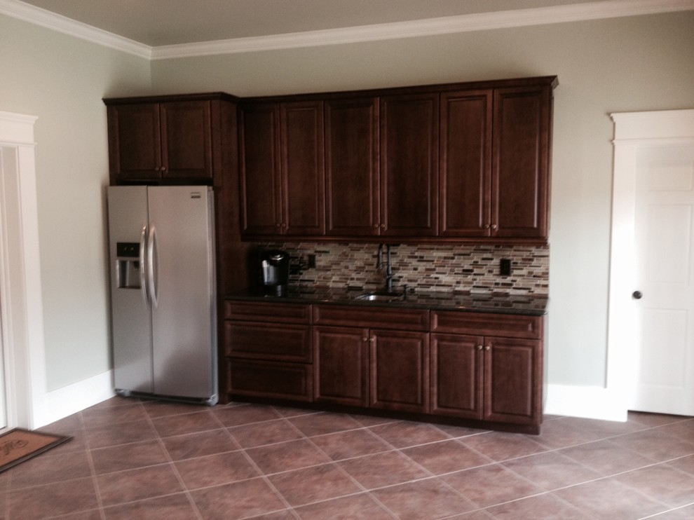 Home design - large transitional single-wall terra-cotta tile home design idea in Charlotte with an undermount sink, raised-panel cabinets, dark wood cabinets, granite countertops, multicolored backsplash, subway tile backsplash, stainless steel appliances and no island