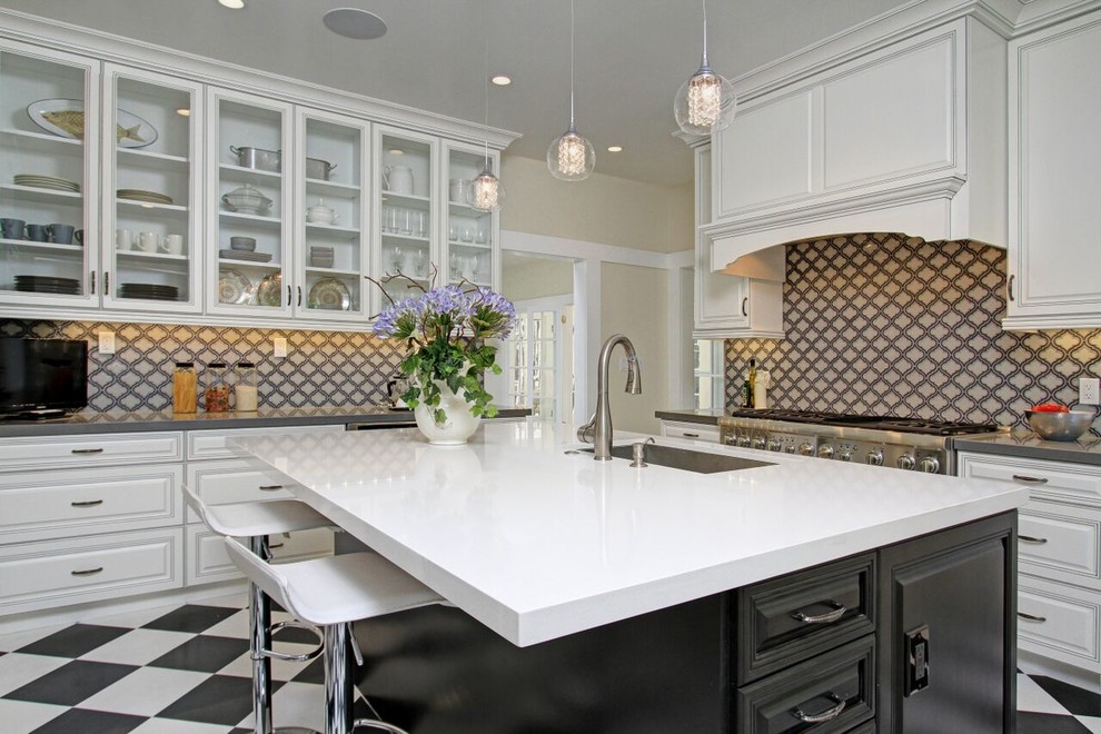 Traditional kitchen in Los Angeles with an undermount sink, raised-panel cabinets, white cabinets, multi-coloured splashback, glass tile splashback, stainless steel appliances and with island.