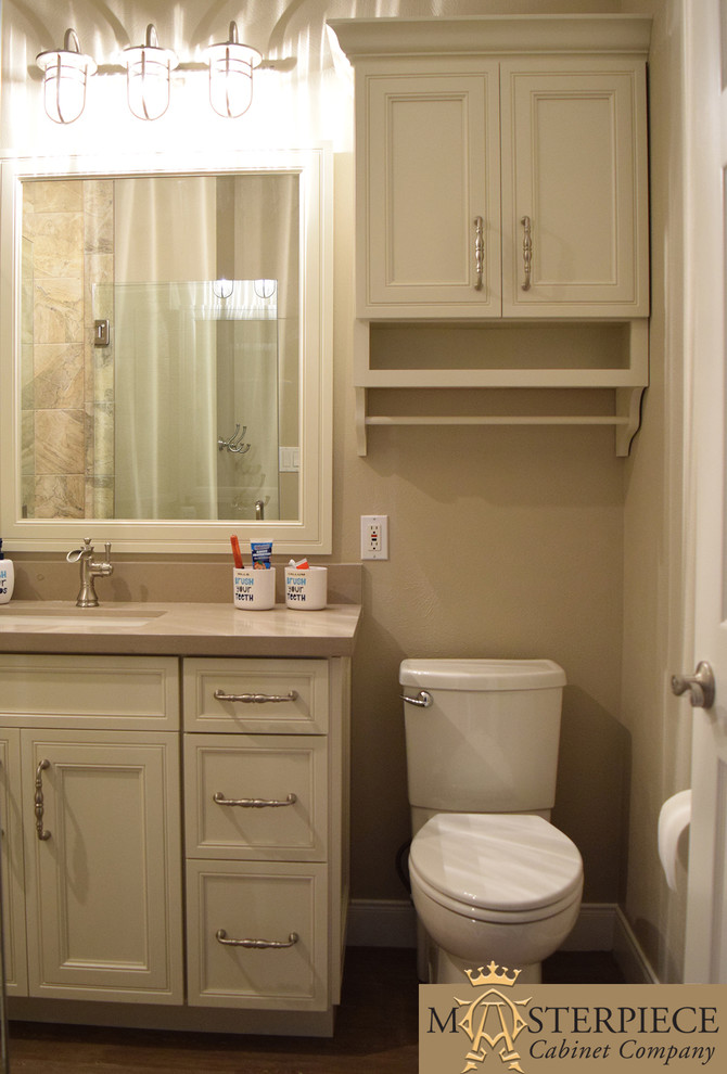 Photo of a mid-sized traditional 3/4 bathroom in Houston with recessed-panel cabinets, white cabinets, an alcove shower, beige walls, an undermount sink, solid surface benchtops, medium hardwood floors, beige tile, brown tile, gray tile and porcelain tile.