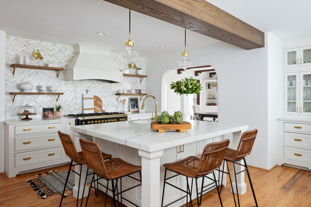 Inspiration for a traditional l-shaped kitchen in New York with shaker cabinets, white cabinets, white splashback, mosaic tile splashback, black appliances, medium hardwood floors, with island, brown floor, white benchtop and exposed beam.