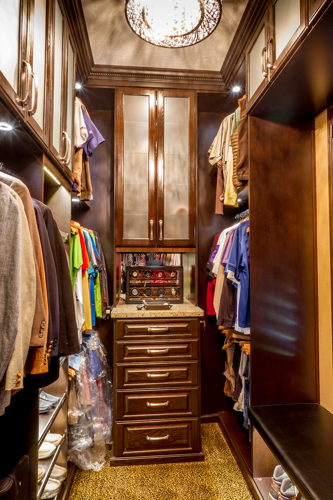 This is an example of a small contemporary gender-neutral walk-in wardrobe in Los Angeles with raised-panel cabinets, dark wood cabinets and carpet.
