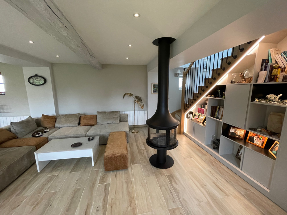 Cette image montre un très grand salon rustique avec un mur beige, un sol en carrelage de céramique, un poêle à bois et un sol beige.