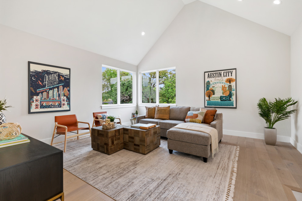 Imagen de sala de estar tipo loft y abovedada de estilo de casa de campo con paredes blancas y suelo de madera clara