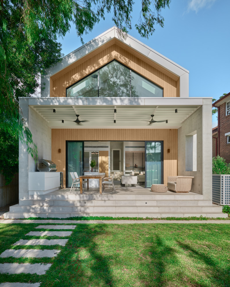 Photo of a contemporary two-storey beige house exterior in Sydney with wood siding and a gable roof.