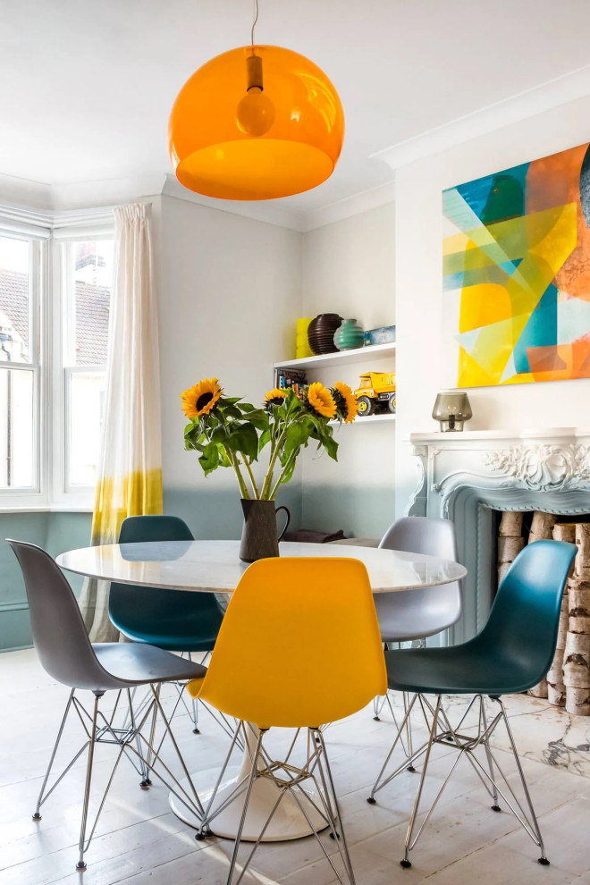 Immagine di una sala da pranzo bohémian con pareti multicolore e camino classico