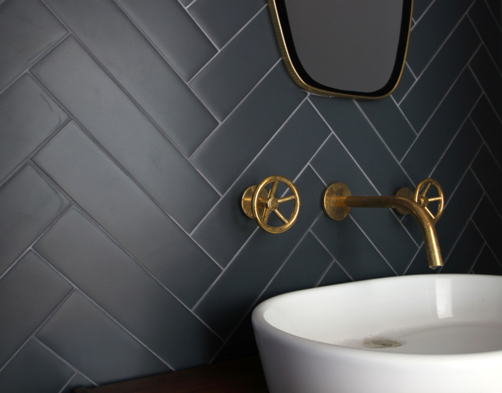 Photo of a mid-sized contemporary powder room in Los Angeles with black tile, porcelain tile, black walls and a vessel sink.