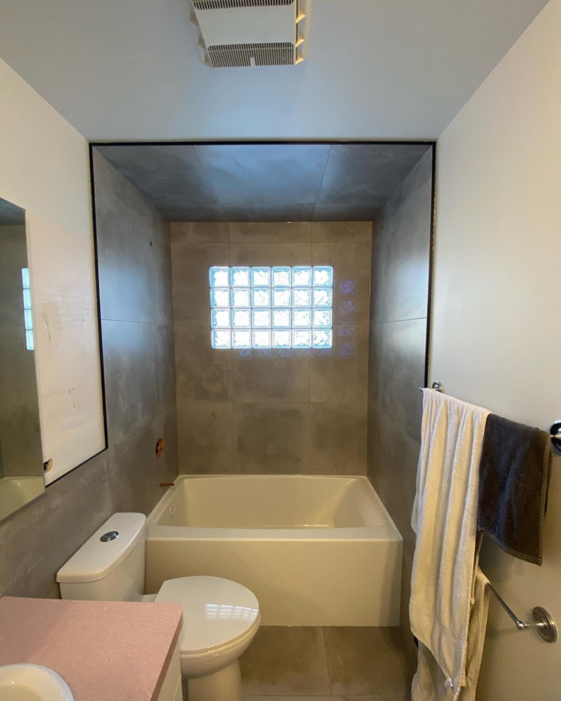 Aménagement d'une salle de bain industrielle de taille moyenne avec une baignoire en alcôve, un combiné douche/baignoire, un carrelage gris, des carreaux de porcelaine, un sol en carrelage de porcelaine, un sol gris et une cabine de douche avec un rideau.