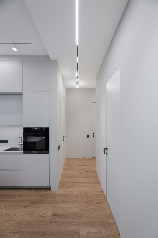 На фото: узкий коридор среднего размера в современном стиле с серыми стенами, темным паркетным полом и коричневым полом