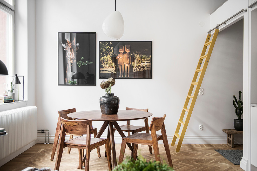 Design ideas for a small scandinavian dining room in Stockholm with white walls, medium hardwood floors and brown floor.