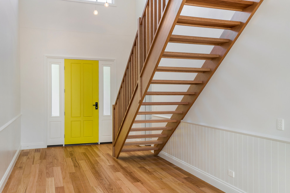 Idée de décoration pour un escalier droit tradition de taille moyenne avec des marches en bois, des contremarches en bois, un garde-corps en bois et boiseries.