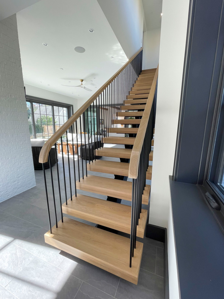 Foto de escalera suspendida minimalista extra grande con escalones de madera, barandilla de varios materiales y machihembrado