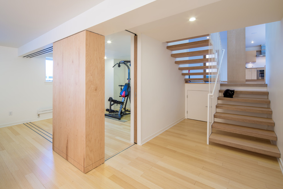 Photo of a modern home gym in Minneapolis with light hardwood floors and white walls.