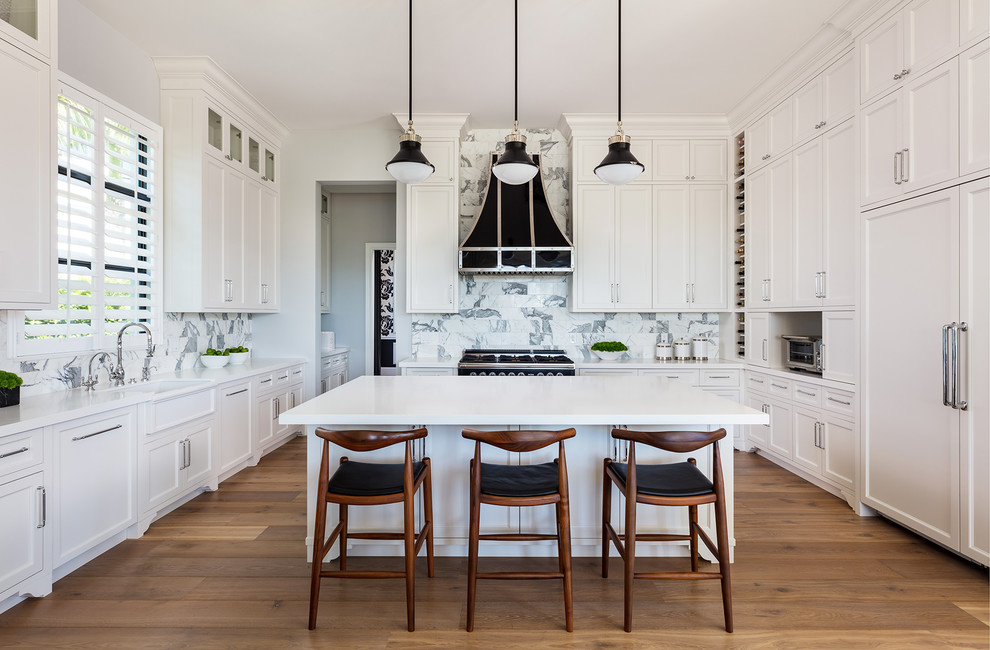Inspiration for a transitional light wood floor kitchen remodel with a farmhouse sink, shaker cabinets, white cabinets, multicolored backsplash, paneled appliances, an island and white countertops