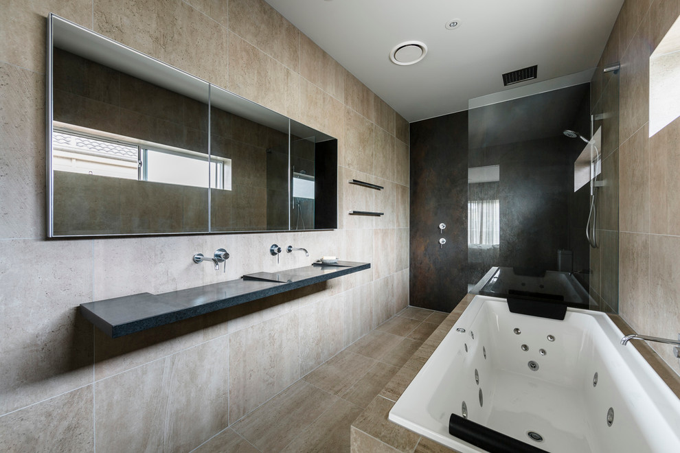 Design ideas for a contemporary bathroom in Sydney with an undermount tub, a two-piece toilet, beige tile, stone slab, beige walls, cement tiles, an integrated sink and onyx benchtops.