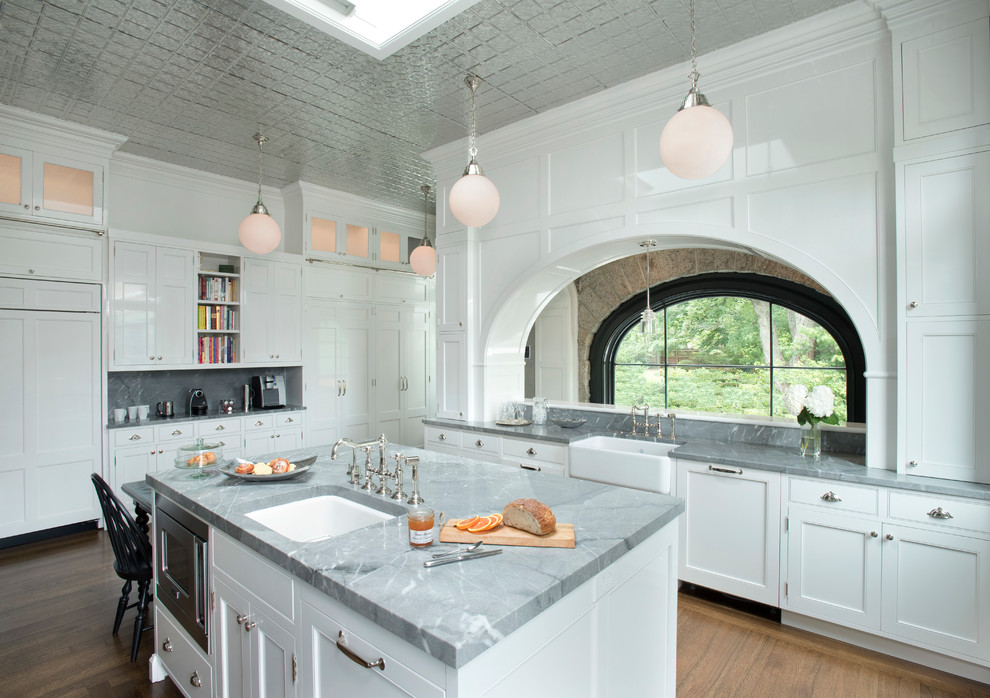 Mid-sized transitional medium tone wood floor kitchen photo in Boston with a farmhouse sink, white cabinets, paneled appliances, an island and beaded inset cabinets