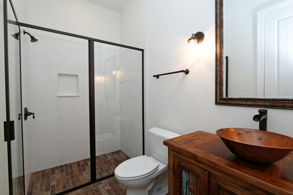 Design ideas for a mid-sized transitional kids bathroom in Orlando with recessed-panel cabinets, brown cabinets, an alcove shower, a one-piece toilet, white tile, ceramic tile, white walls, brick floors, an undermount sink and wood benchtops.