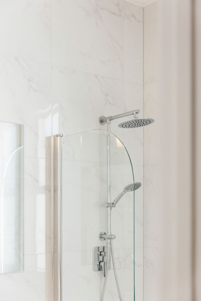 Photo of a mid-sized traditional master bathroom in Auckland with glass-front cabinets, white cabinets, an open shower, a wall-mount toilet, white tile, marble, white walls, porcelain floors, a drop-in sink, engineered quartz benchtops, white floor, an open shower and white benchtops.