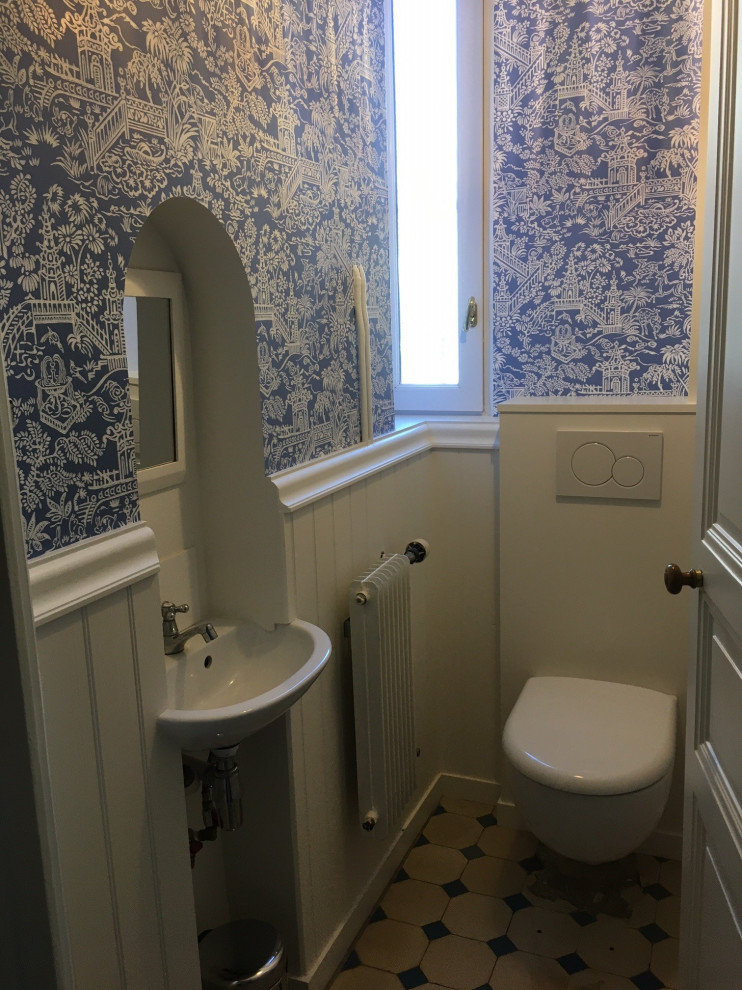 アンジェにあるお手頃価格の小さなトランジショナルスタイルのおしゃれなトイレ・洗面所 (壁掛け式トイレ、青い壁、セメントタイルの床、壁付け型シンク、グレーの床、塗装板張りの壁) の写真