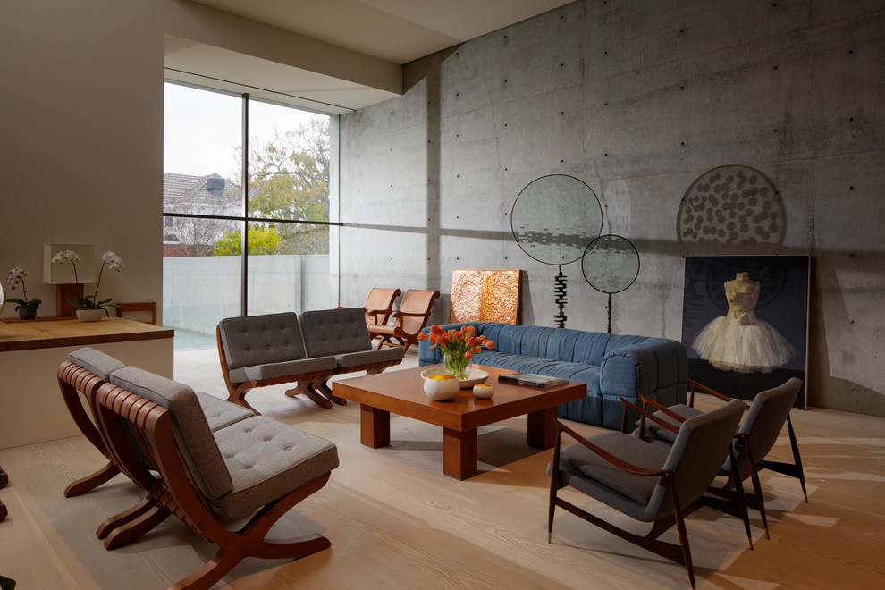 Industrial living room in Melbourne with grey walls, medium hardwood floors and brown floor.