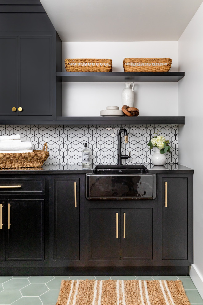 Design ideas for a mid-sized transitional galley dedicated laundry room in Salt Lake City with a farmhouse sink, flat-panel cabinets, black cabinets, quartzite benchtops, white splashback, ceramic splashback, terra-cotta floors, a side-by-side washer and dryer, green floor, black benchtop and coffered.