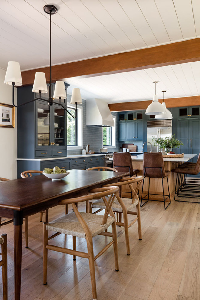 Idée de décoration pour une salle à manger ouverte sur la cuisine design de taille moyenne avec un mur multicolore, un sol en bois brun et aucune cheminée.