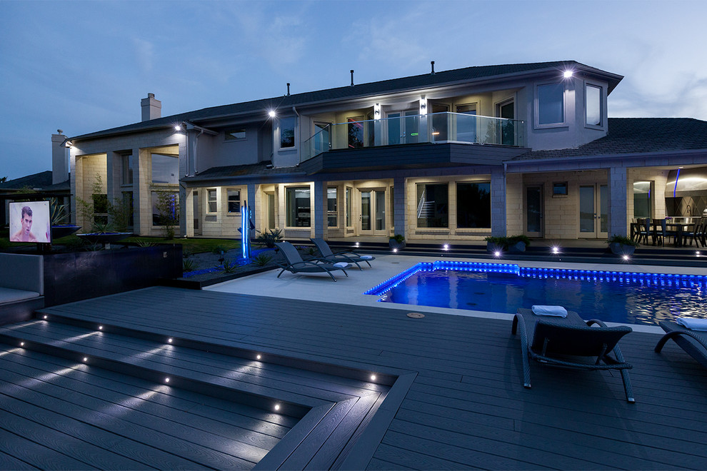 This is an example of a large contemporary backyard rectangular lap pool in Dallas with a hot tub and concrete slab.