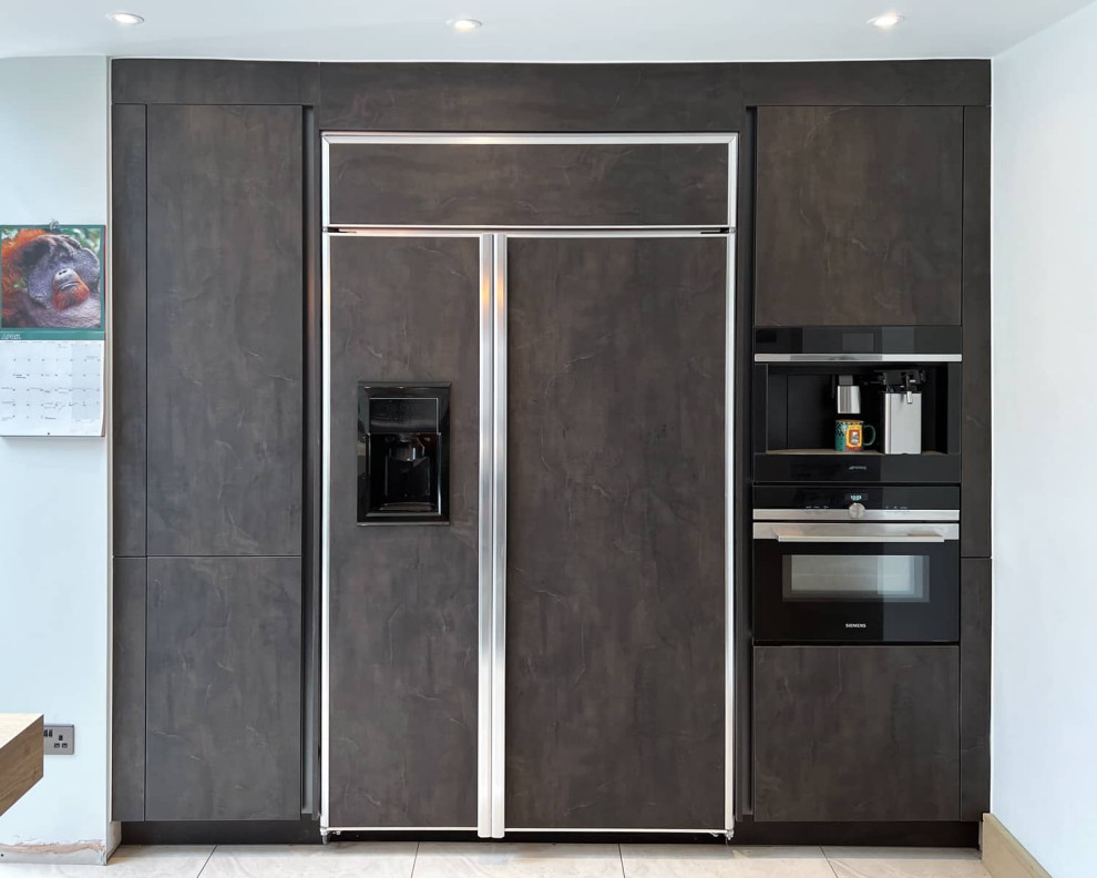 This is an example of a large industrial l-shaped open plan kitchen in London with brown cabinets, stainless steel appliances, ceramic flooring, an island, grey floors and brown worktops.