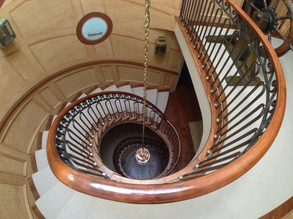 This is an example of an expansive traditional wood spiral staircase in New York with wood risers and mixed railing.