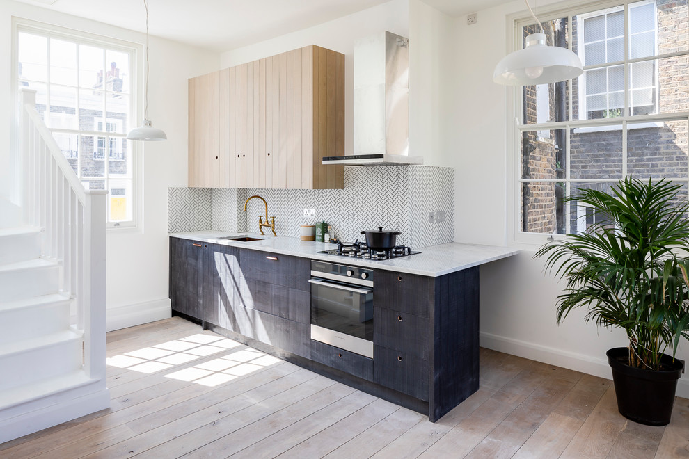 Inspiration for a small scandinavian single-wall kitchen in London with an undermount sink, marble benchtops, white splashback, matchstick tile splashback, no island, brown floor, white benchtop, flat-panel cabinets, black cabinets, black appliances and medium hardwood floors.
