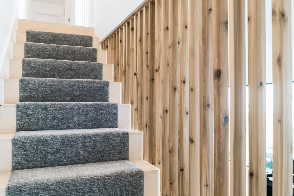 Mid-sized arts and crafts wood straight staircase in Austin with carpet risers and wood railing.