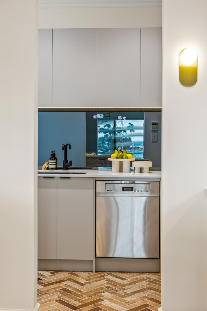 Inspiration for a large contemporary l-shaped kitchen pantry in Perth with an undermount sink, granite benchtops, white splashback, marble splashback, stainless steel appliances, medium hardwood floors, with island, brown floor and white benchtop.