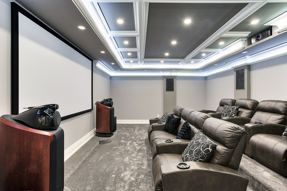 Photo of a traditional enclosed home theatre in Toronto with grey walls, carpet, a projector screen and grey floor.