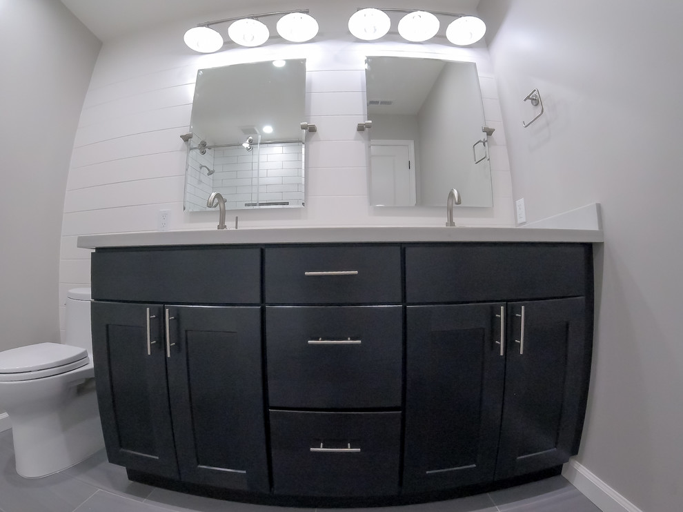 Mid-sized transitional bathroom in San Francisco with flat-panel cabinets, dark wood cabinets, a drop-in tub, a shower/bathtub combo, a one-piece toilet, grey walls, an undermount sink, marble benchtops, a sliding shower screen and white benchtops.