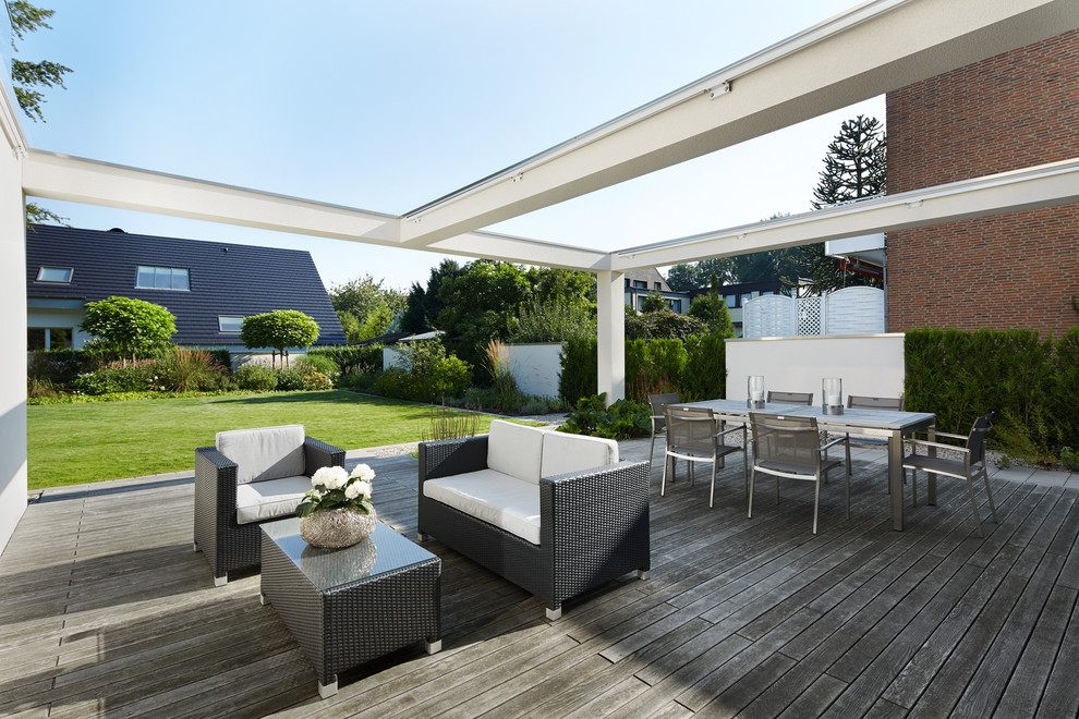 Photo of a large contemporary deck in Nuremberg with a roof extension.