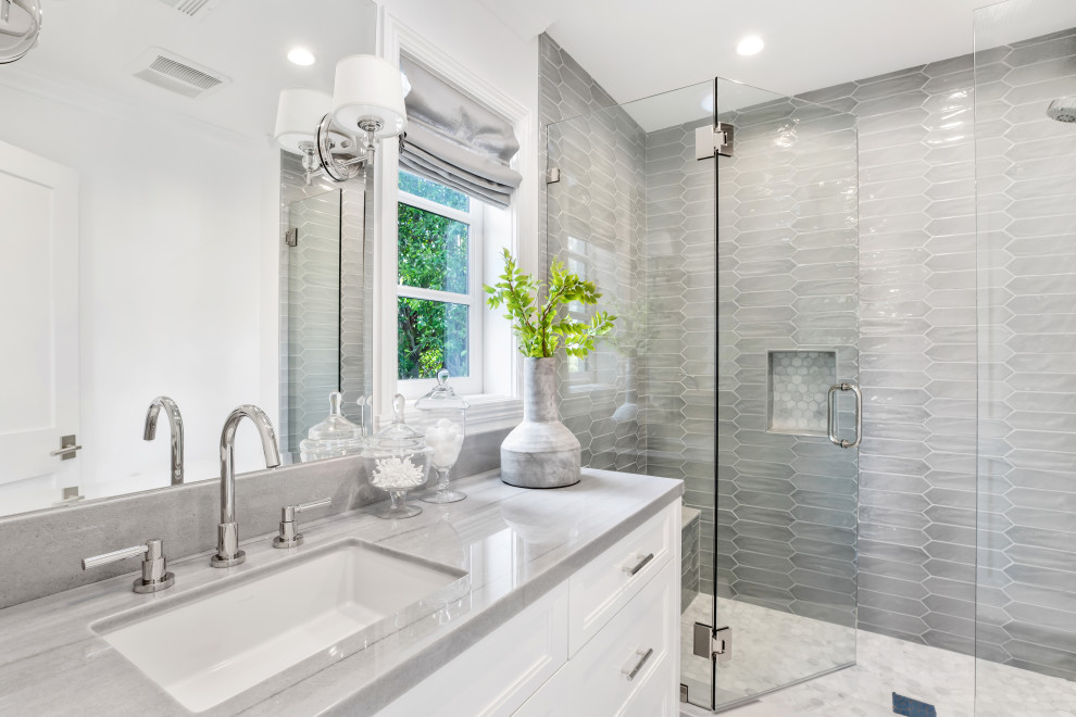 Inspiration for a transitional 3/4 bathroom in Los Angeles with recessed-panel cabinets, white cabinets, an alcove shower, gray tile, white walls, an undermount sink, white floor, a hinged shower door, grey benchtops, a niche, a single vanity and a built-in vanity.