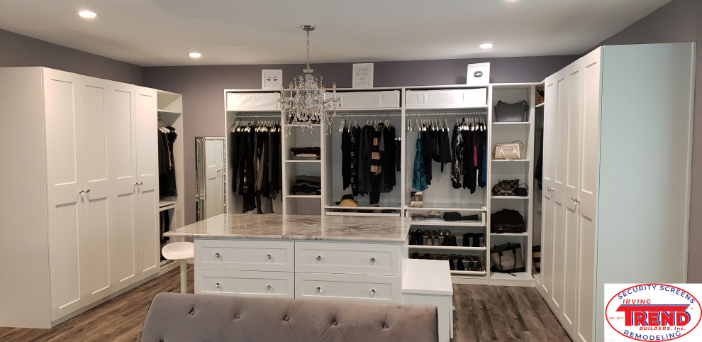 This is an example of a contemporary walk-in wardrobe in Dallas with shaker cabinets, laminate floors and white cabinets.