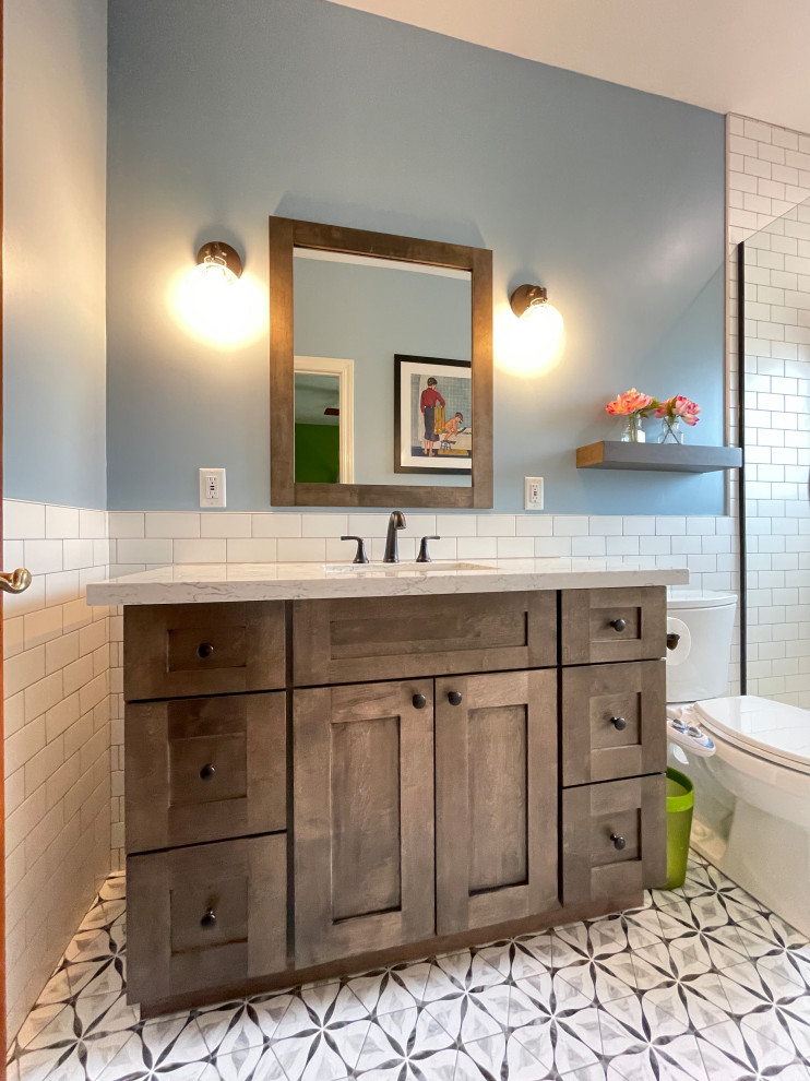 Design ideas for a mid-sized transitional kids bathroom in Phoenix with recessed-panel cabinets, dark wood cabinets, an alcove shower, yellow tile, travertine, blue walls, porcelain floors, an undermount sink, engineered quartz benchtops, grey floor, an open shower, white benchtops, a single vanity and a built-in vanity.