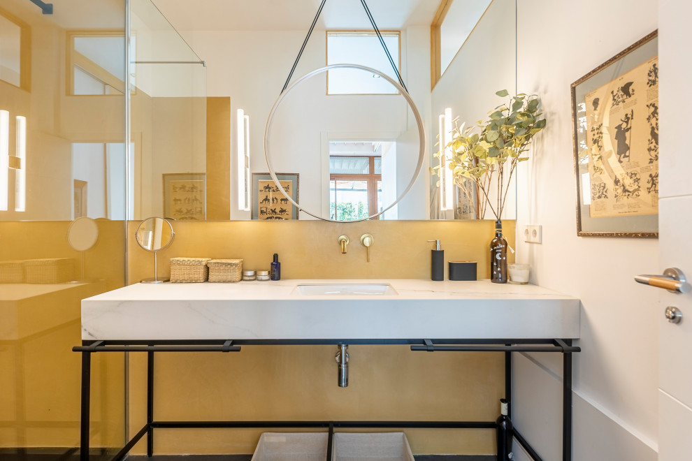 Пример оригинального дизайна: ванная комната в современном стиле с открытыми фасадами, желтой плиткой, белыми стенами, врезной раковиной, черным полом, белой столешницей, тумбой под одну раковину и напольной тумбой