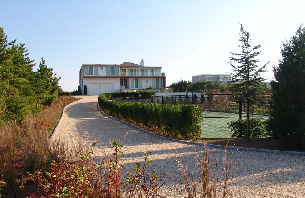 This is an example of a large traditional front yard partial sun driveway in New York with gravel and a garden path.