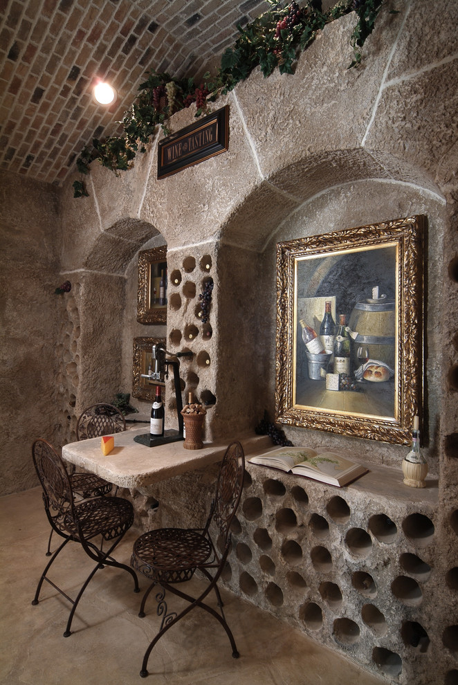 This is an example of a large mediterranean wine cellar in Austin with concrete floors, storage racks and brown floor.