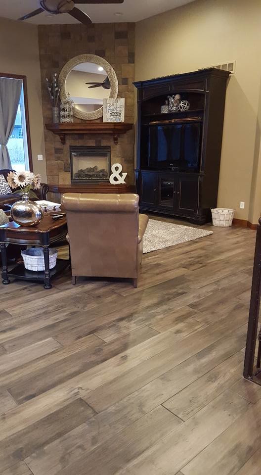 Inspiration for a mid-sized traditional open concept family room in Omaha with brown walls, medium hardwood floors, a corner fireplace and a concealed tv.