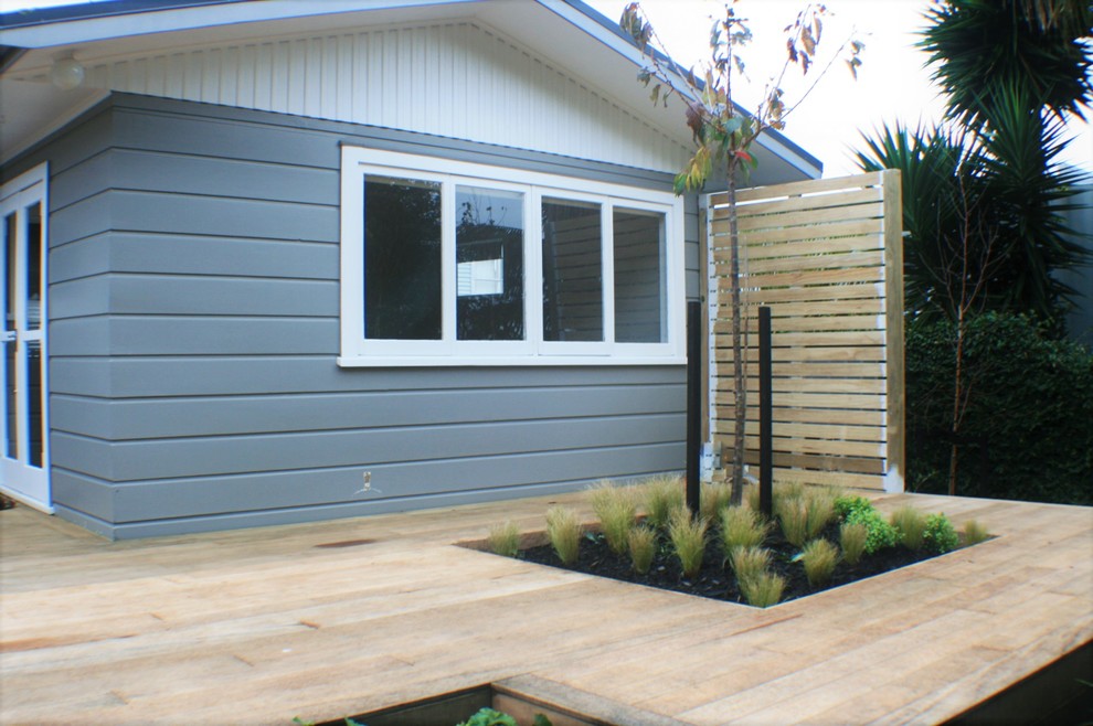 Small contemporary backyard partial sun garden in Auckland with decking for summer.