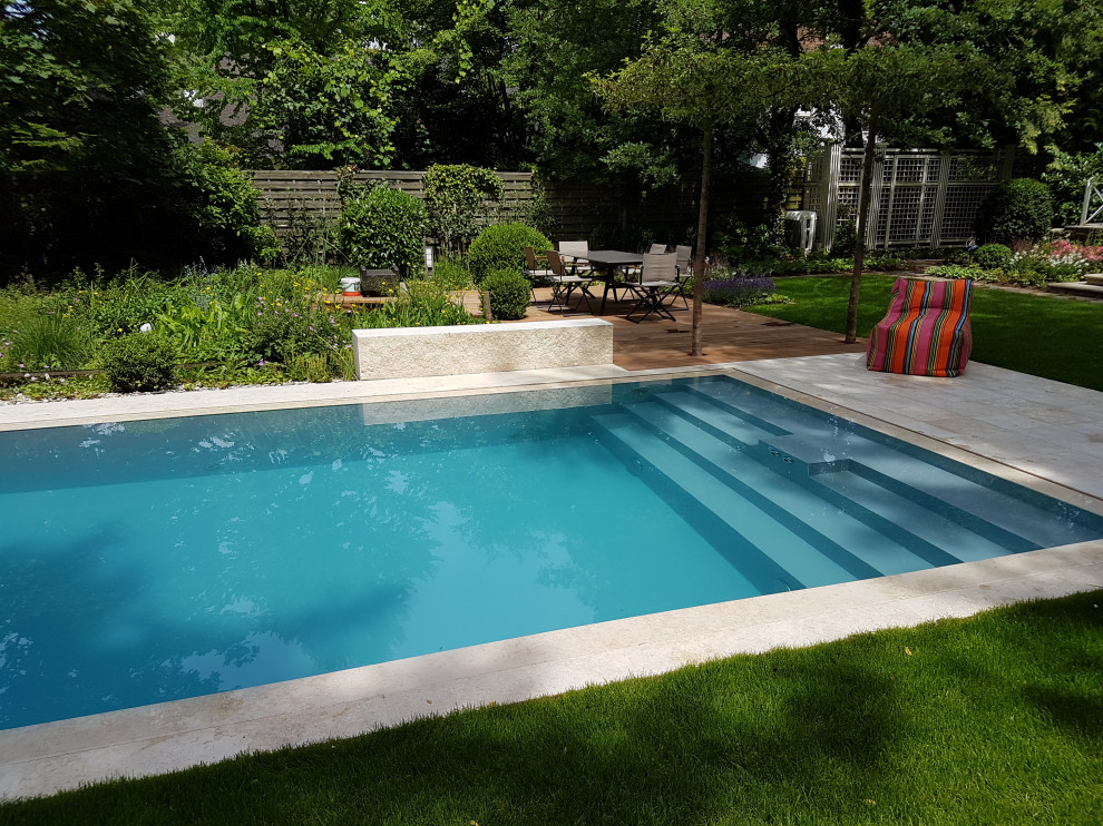 Photo of a large contemporary side yard rectangular infinity pool in Frankfurt with natural stone pavers.