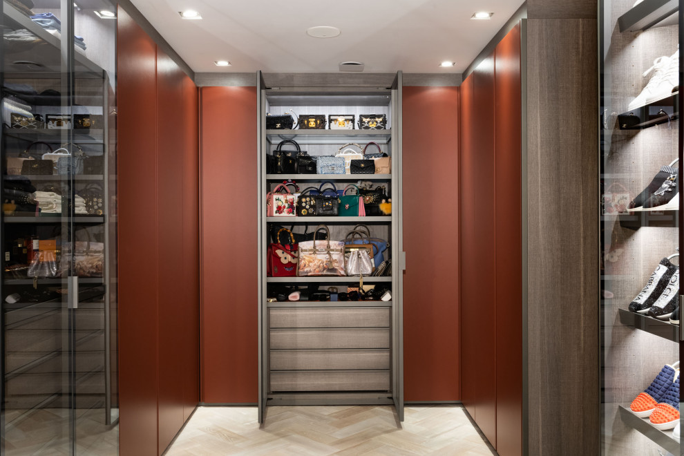 Design ideas for an expansive contemporary women's walk-in wardrobe in London with light hardwood floors, beige floor and flat-panel cabinets.