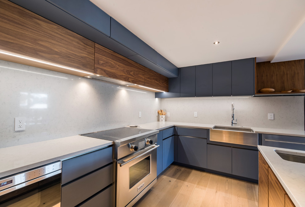Modern Kitchen with Handleless Cabinets - The polished set-up of flat-panel cabinets and built-in appliances maximizes the kitchen's function. On the other hand, the combination of gray, wood, and stainless, gives vibrancy and modish look to the entire kitchen. Likewise, the light and plain backsplash accents a clean view.

Built by ULFBUILT. Contact us today to learn more.