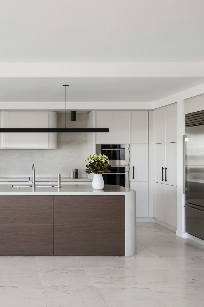 Inspiration for an expansive modern l-shaped open plan kitchen in Sydney with an undermount sink, shaker cabinets, beige cabinets, solid surface benchtops, beige splashback, stainless steel appliances, marble floors, with island, white floor and beige benchtop.
