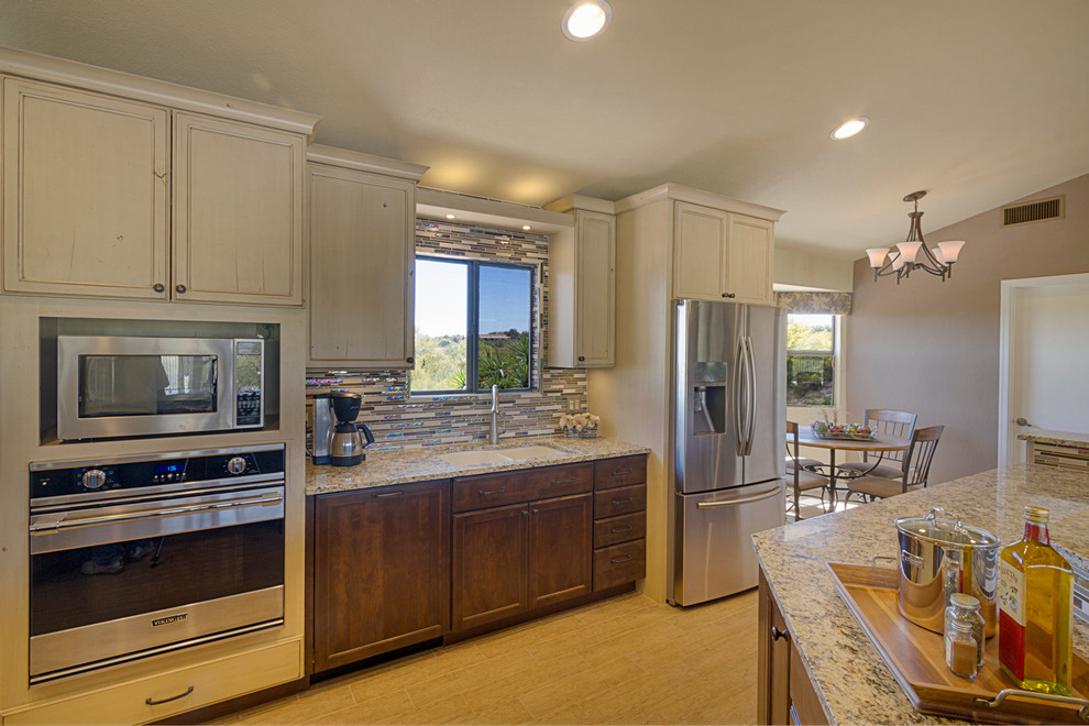 Example of a huge transitional single-wall porcelain tile open concept kitchen design in Phoenix with an undermount sink, glass-front cabinets, granite countertops, glass tile backsplash, stainless steel appliances and two islands