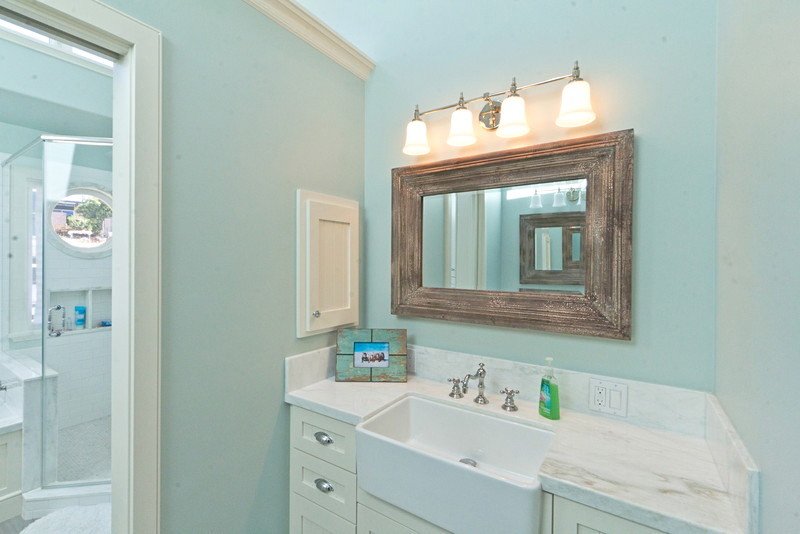 Photo of a mid-sized traditional kids bathroom in Santa Barbara with shaker cabinets, white cabinets, a drop-in tub, a corner shower, a two-piece toilet, white tile, ceramic tile, blue walls, medium hardwood floors, a drop-in sink and marble benchtops.